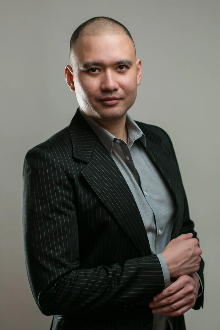 DJ Selphi in a pinstripe suit, arms folded
